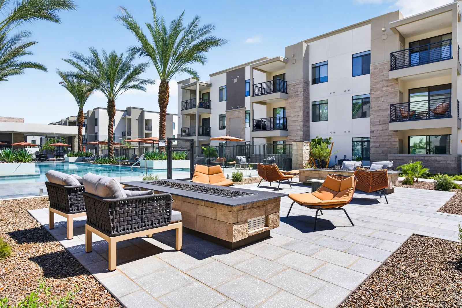 Fire pit lounge with patio seating beside the pool at Harmony at Hawes Crossing