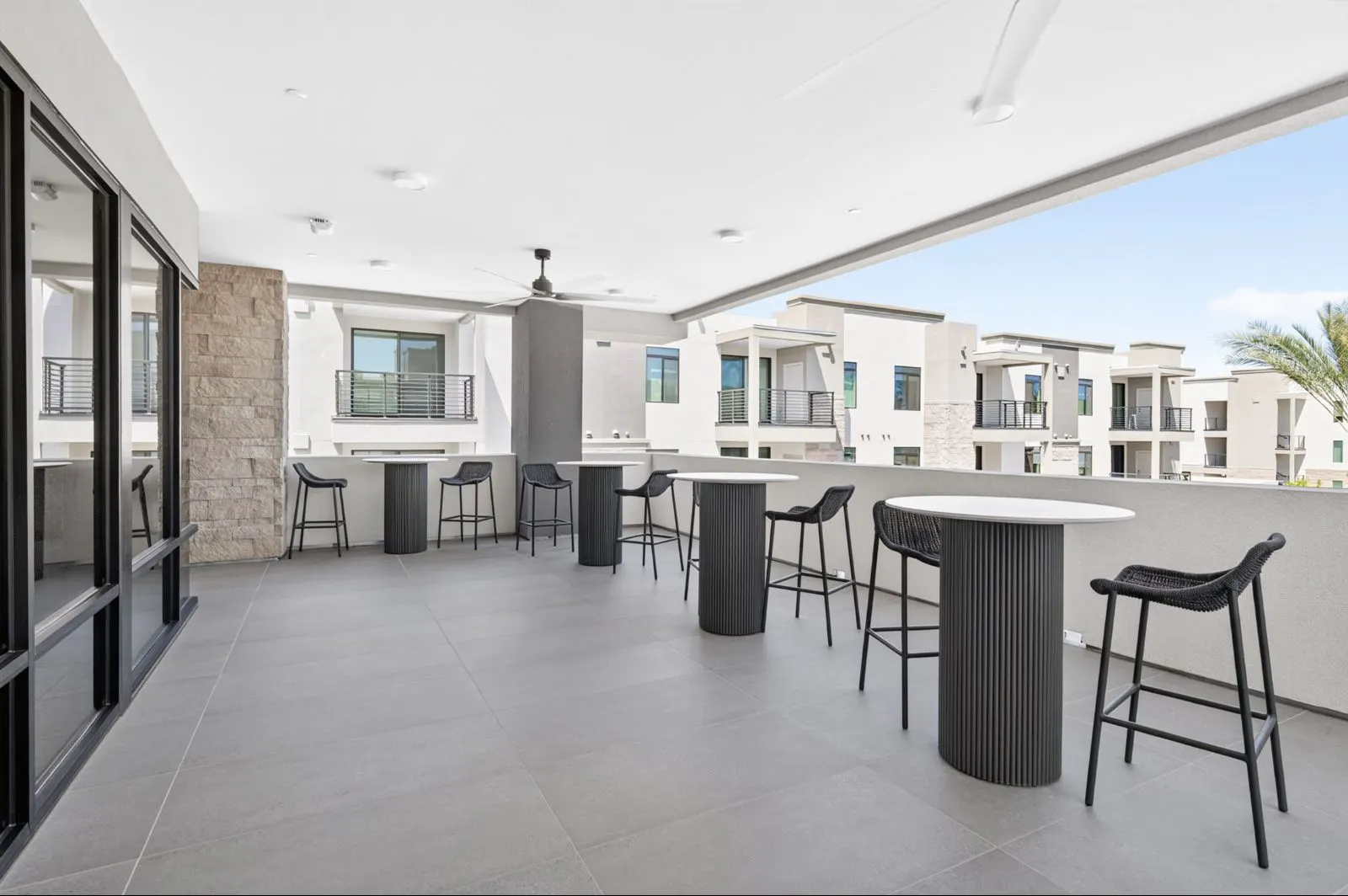 Covered terrace with high-top tables and bar stools at Harmony at Hawes Crossing