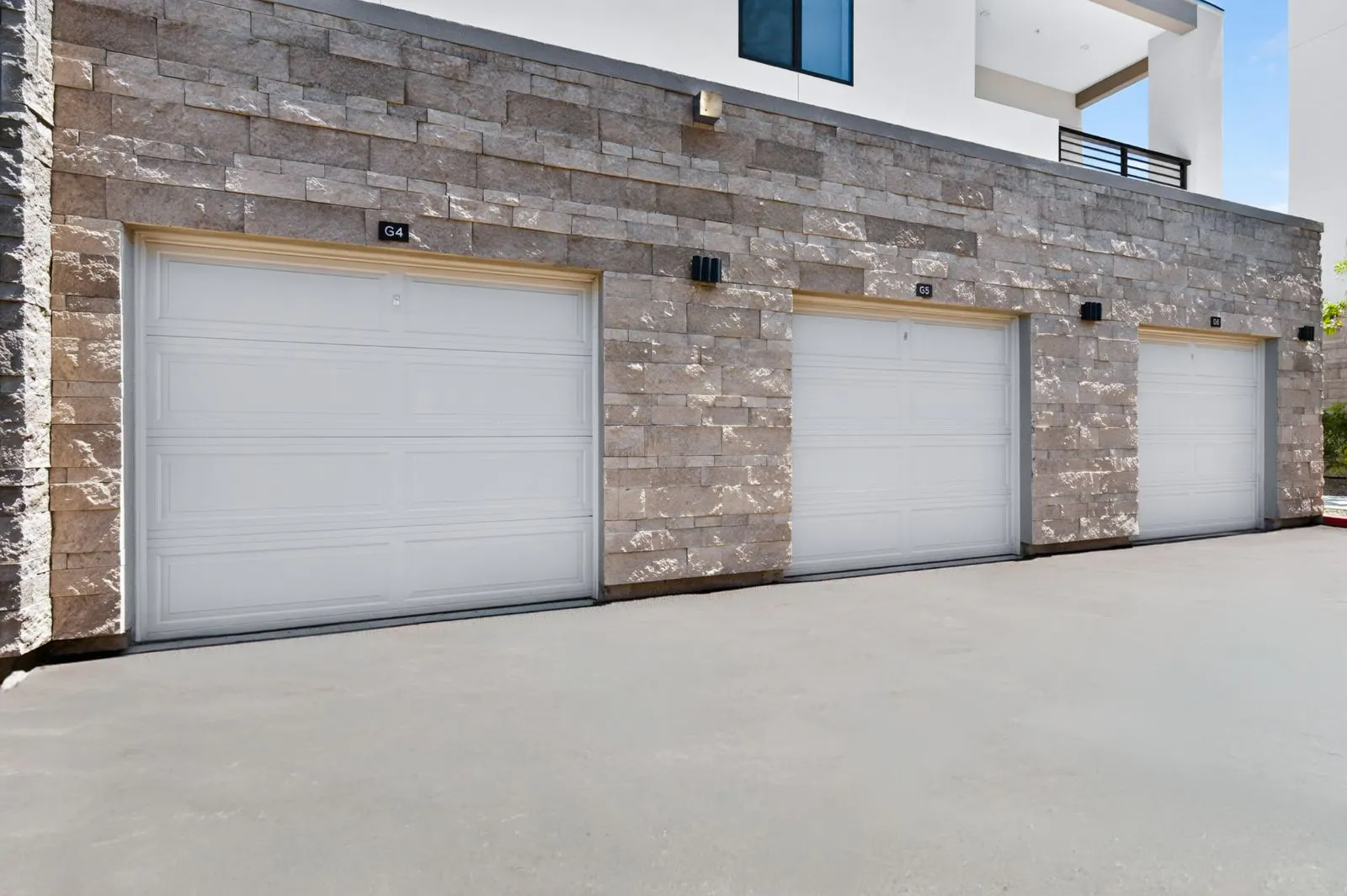 Detached garages with stone facade at Harmony at Hawes Crossing