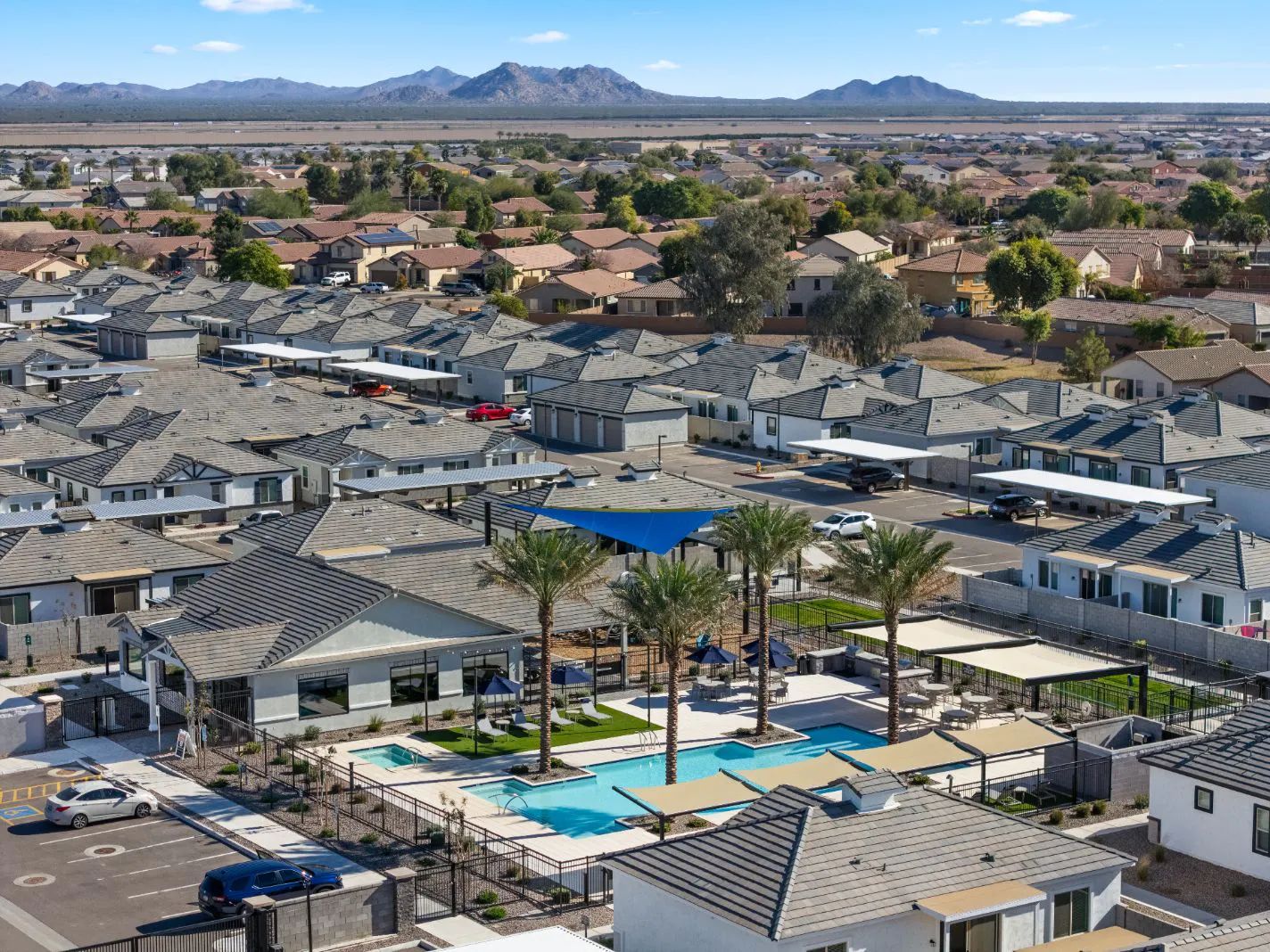 Aerial view of the pool, shade structures and clubhouse with mountains beyond at Honeycutt Run